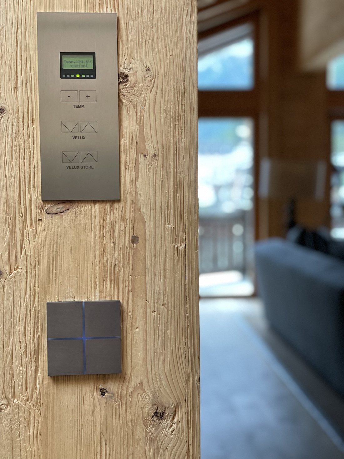 Painel de climatização e teclado KNX em metal escovado sobre madeira antiga de chalet
